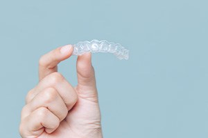 a person holding an Invisalign tray