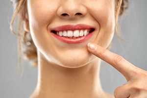 close up woman pointing to her smile