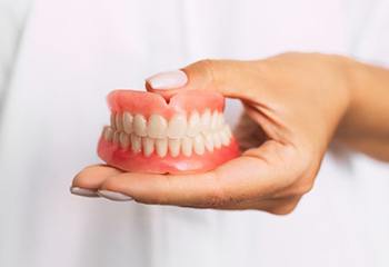 dentist holding full dentures