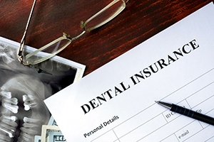 Dental insurance form on desk with pen