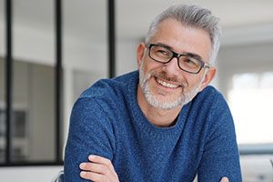 Man with glasses smiling with dental implants in South Portland, ME