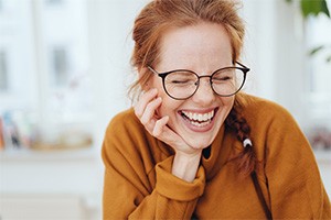 Young woman smiling after cosmetic smile makeover