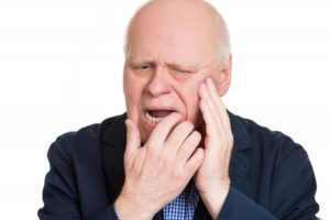 Man with hand on face has broken denture in quarantine