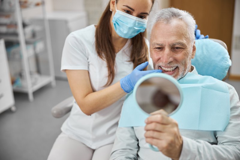 senior man smiling with dental implants