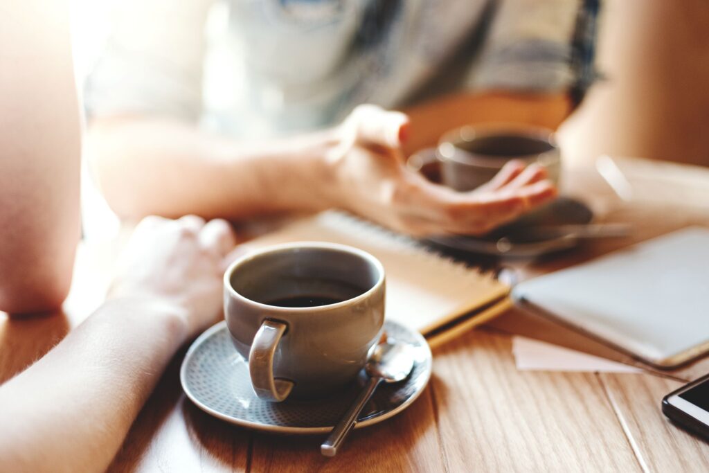 Hands at table with cups of coffee